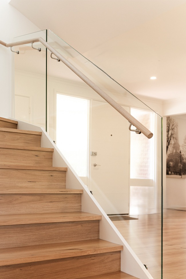 Modern timber staircase with glass balustrade and wooden handrail